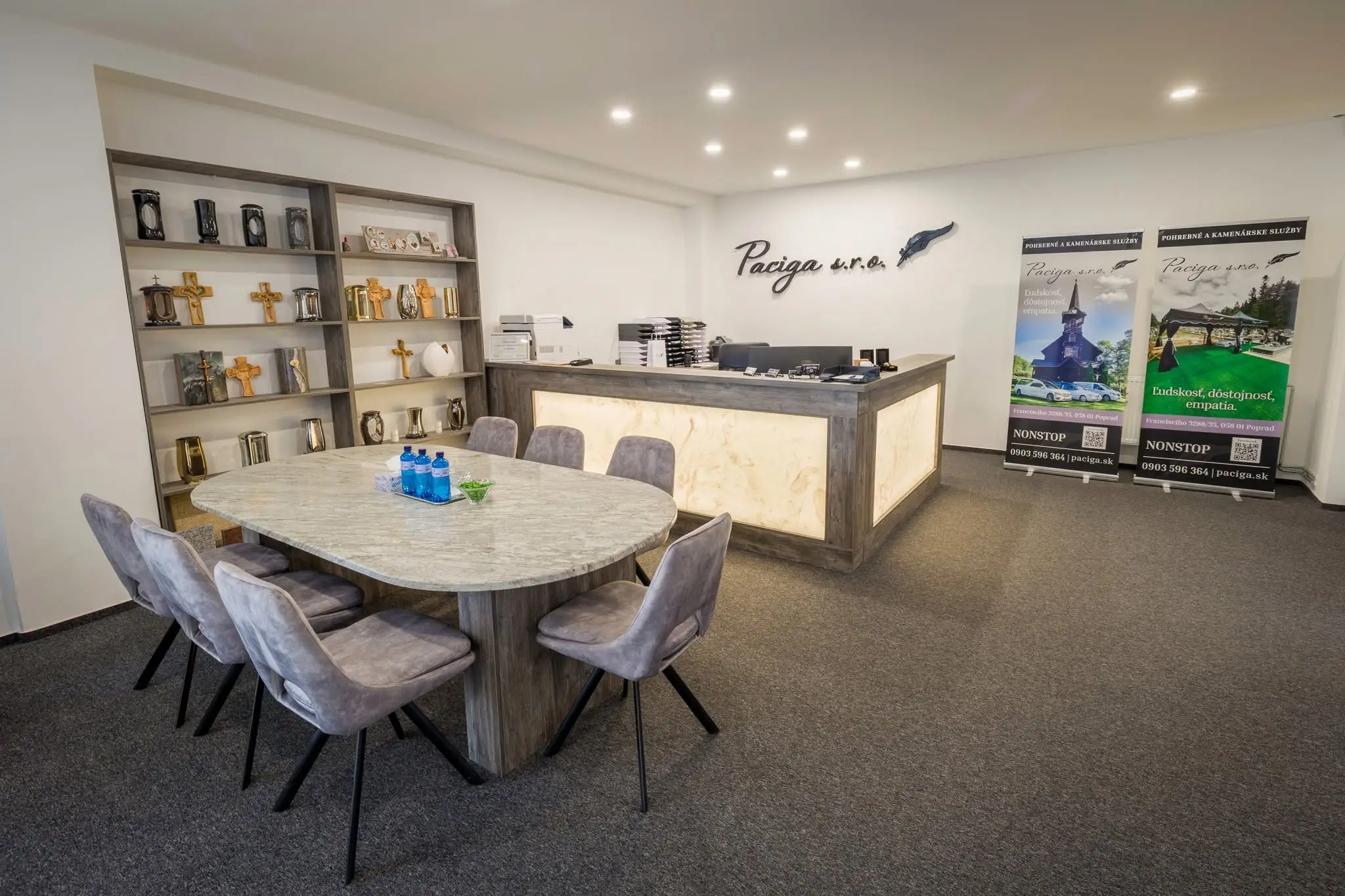 Interiér pobočky Poprad: showroom s urnami, krížmi a stolom na osobné stretnutie