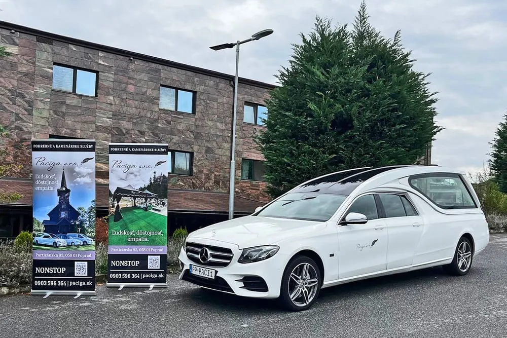 Biela pohrebná limuzína Mercedes-Benz E 400 Paciga pred pobočkou