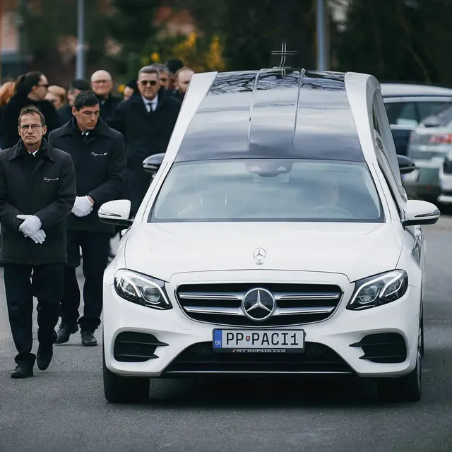 Biela pohrebná limuzína Paciga so smútočným sprievodom